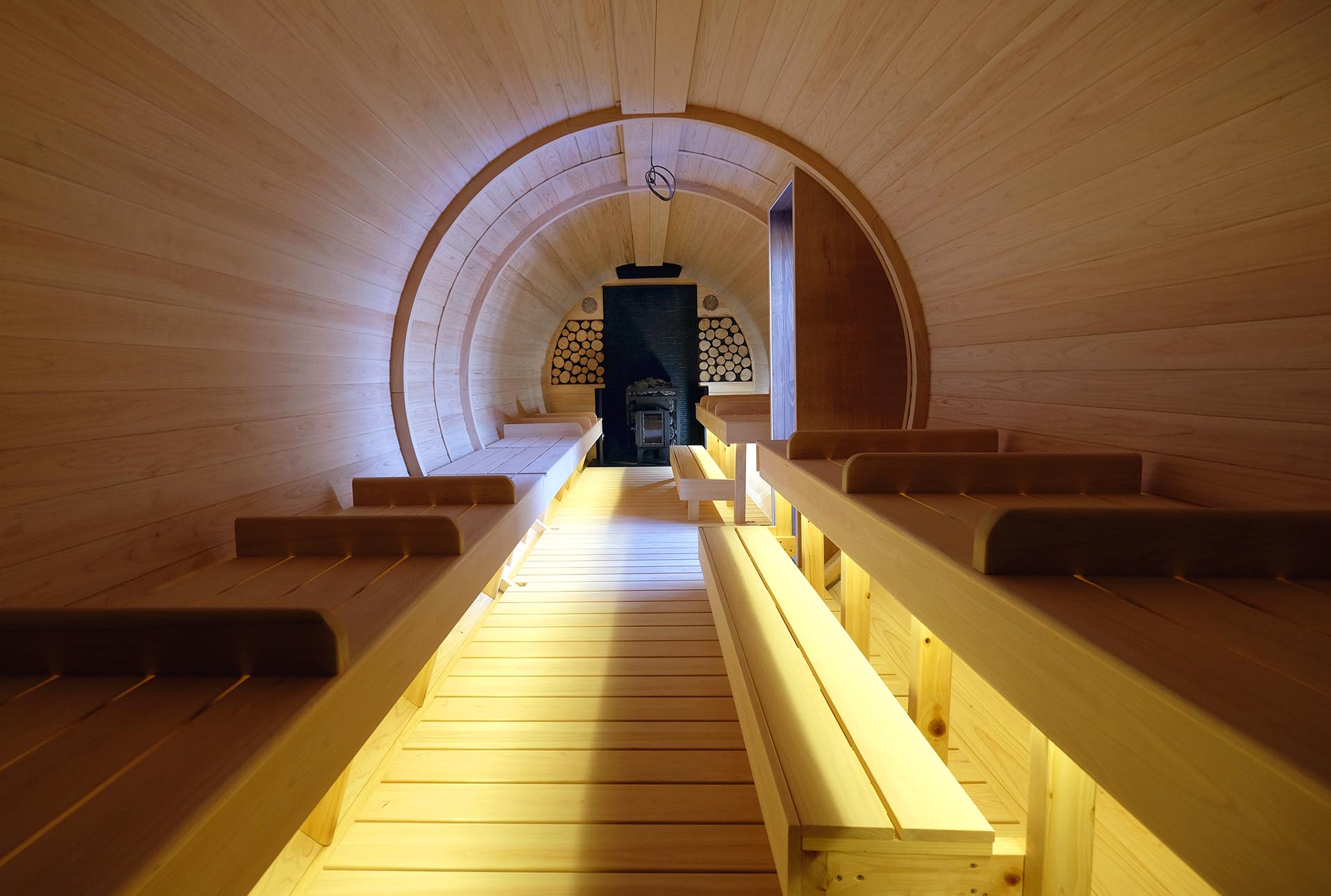 バレルサウナ内部。芳醇なヒノキの香りに包まれる空間、ヒノキ造りベンチと、美しい木目の天井、リラックス効果の高い至高の「整う」サウナ体験